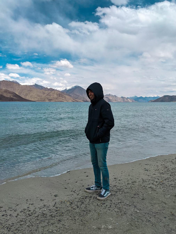 Utkarsh in front of a glacial lake in the Himalayas.